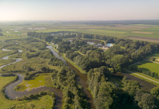 Aerial view of the safari tent Hunzepark 15, featuring winding rivers, trees and open fields in the Netherlands.