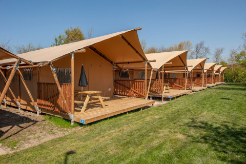 Safari-Zelte mit Holzterrassen im Ferienpark «Hunzedal 17» in den Niederlanden, sonniges Wetter.