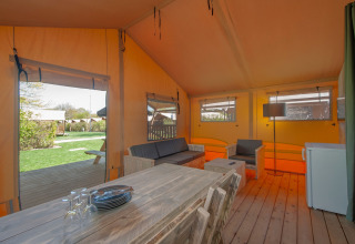 Innenaufnahme eines Safarizelts im Holiday Park Hunzedal 17 in den Niederlanden mit Holzmöbeln.