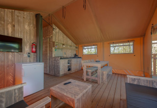 Innenraum eines Safari-Zeltes im Ferienpark «Hunzedal 17», Niederlande, mit Holzmöbeln und Küchenzeile.