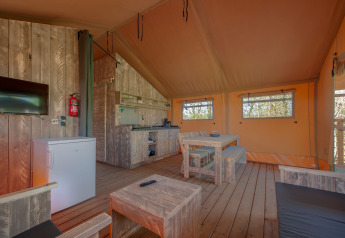Interior de una tienda safari en Holiday Park «Hunzedal 17», Países Bajos, con muebles rústicos de madera.