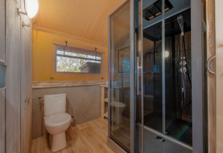Moderne badeværelse i safaritelt på Holiday Park Hunzedal 17, Holland, med bruseniche og toilet.