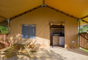 Tienda safari con mesa de picnic de madera y cocina exterior en Holiday Park Hunzedal 17 en Países Bajos.