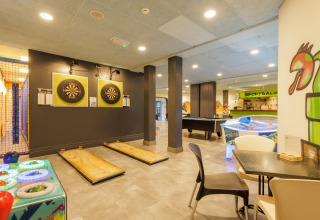 Binnen speelruimte bij safaritent Holiday Park ‘Hunzedal 17’ in Nederland met darts en speelautomaten.