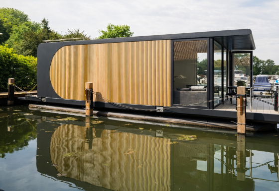 Houseboat moderno con pannelli in legno e pareti di vetro ormeggiato a Lemmer, Frisia, Paesi Bassi.