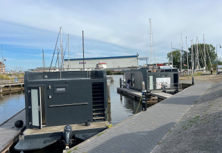 Case galleggianti moderne a Marina Lemmer nei Paesi Bassi, con barche a vela e vista sull'acqua.