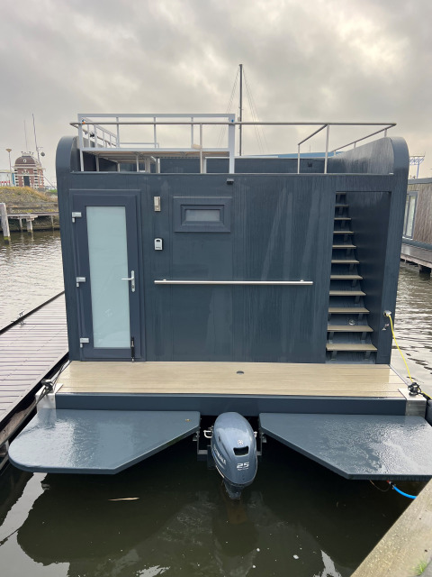 Moderne woonboot met terras, glazen deur en trap bij Marina Lemmer, Friesland, Nederland.