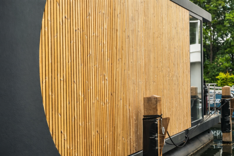 Detailansicht der modernen Holzverkleidung eines Luxus-Hausboots im Jachthafen Lemmer, Niederlande.