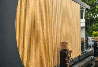 Detalle de revestimiento de madera moderna en una casa flotante de lujo en Marina Lemmer, Países Bajos.
