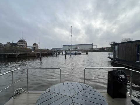 Blick von einem Hausboot in der Marina Lemmer in den Niederlanden auf das Wasser, Boote und einen wolkigen Himmel.