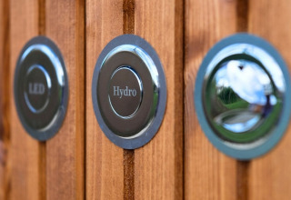 Primer plano de botones LED y Hydro en paneles de madera en Wood Cottage con jacuzzi en los Países Bajos.
