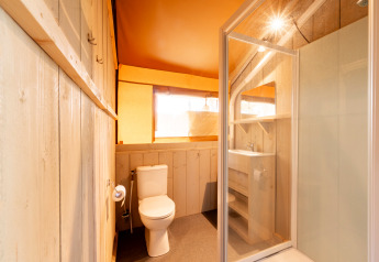 Badkamer in de Nomad safaritent op Camping Vilanova Park in Spanje met douche en toilet.