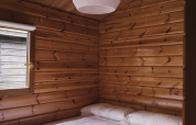 Dormitorio con paredes de madera y cama doble en Bungalow Basic Family de Wecamp Cudillero, España.