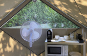 Innenraum eines Safari-Zelts mit Ventilator, Mikrowelle und Kaffeemaschine im Wecamp Cudillero, Spanien.