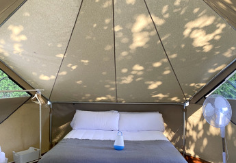 Interno di una Bell Tent al Wecamp Cudillero in Spagna con letto matrimoniale e ventilatore.