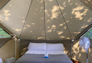 Interno di una Bell Tent al Wecamp Cudillero in Spagna con letto matrimoniale e ventilatore.