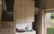 Interieur van Tiny Home 'Family Wood' bij Wecamp Cudillero in Spanje, met moderne compacte keuken.