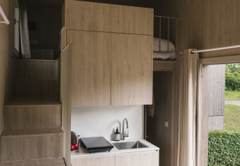 Vue intérieure du Tiny Home « Family Wood » à Wecamp Cudillero en Espagne avec cuisine compacte.