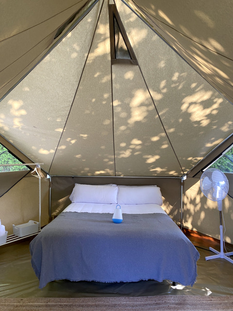 Binnenkant van de Bell Tent Plus safaritent bij Wecamp Cudillero in Spanje met een dubbel bed.