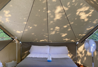 Intérieur de la tente safari Bell Tent Plus à Wecamp Cudillero en Espagne avec un grand lit.