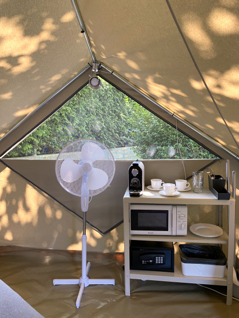 Interieur van een Bell Tent Plus bij Wecamp Cudillero met ventilator, koffiezetapparaat en magnetron.