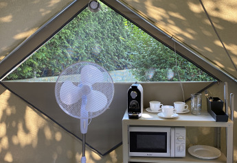 Intérieur d’une Bell Tent Plus au Wecamp Cudillero avec ventilateur, machine à café et micro-ondes.