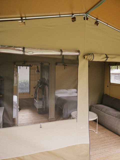 Intérieur de la tente safari Cottage Family Tent au Wecamp Cudillero en Espagne, avec lits et canapé.