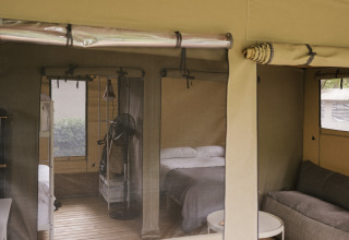 Intérieur de la tente safari Cottage Family Tent au Wecamp Cudillero en Espagne, avec lits et canapé.