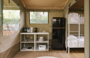 Innenansicht des Cottage Family Tents bei Wecamp Cudillero in Spanien mit Küche und Etagenbetten.