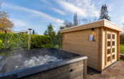 Udendørs spabad og sauna ved Forest lodge i Holiday center 't Schuttenbelt, Holland, på en solrig dag.