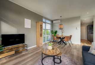 Modern living and dining area at Forest Lodge, Holiday center 't Schuttenbelt in the Netherlands, with wood accents.