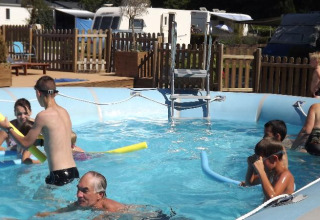 Børn og voksne nyder en udendørs swimmingpool med legetøj på Flower Camping de la Trye i Hauts-de-France.
