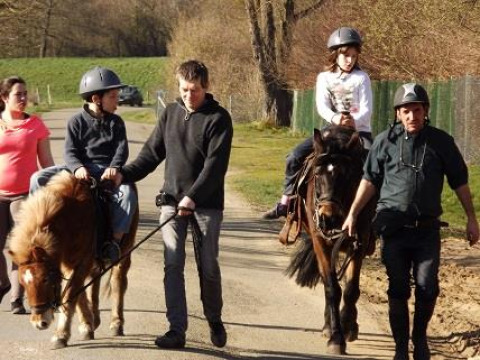 Børn nyder en ponytur ledsaget af voksne på Flower Camping de la Trye i Hauts-de-France, Frankrig.