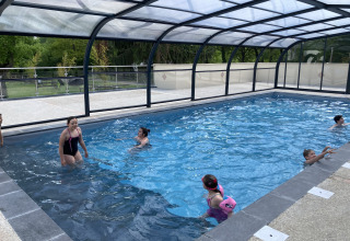 Overdekt zwembad met spelende kinderen bij Flower Camping de la Trye, vakantiepark in Hauts-de-France.