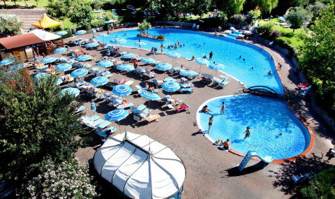 Udsigt over poolområde med liggestole og parasoller i Centro Vacanze San Marino feriepark, San Marino.