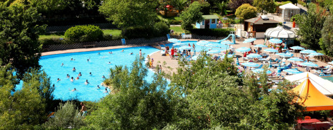 Centro Vacanze San Marino vakantiepark met een zwembad, ligstoelen en parasols te midden van natuur.