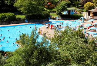 Centro Vacanze San Marino, parque vacacional con gran piscina, tumbonas y sombrillas rodeado de naturaleza.