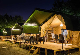 Avondsfeer bij glampingtenten in Centro Vacanze San Marino, omringd door bomen en rustige natuur.