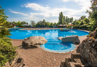 Piscine extérieure avec rochers et verdure au Centro Vacanze San Marino, parc de vacances à Saint-Marin.