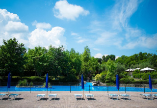 Udendørs swimmingpool og solsenge i Centro Vacanze San Marino, omgivet af træer under blå himmel.