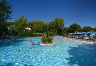 Piscina all'aperto con persone, palme e lettini a Centro Vacanze San Marino, San Marino.