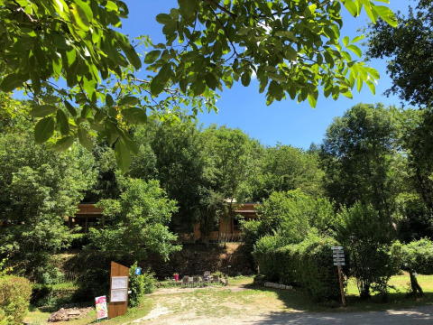 Campeggio immerso nel verde al Moulin de Chaules, parco vacanze in Auvergne-Rhône-Alpes, Francia, con sole.