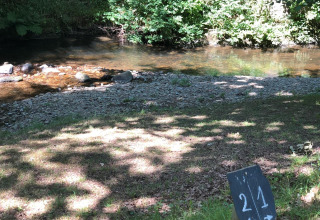 Riva ombreggiata al campeggio Moulin de Chaules in Alvernia-Rodano-Alpi, con cartello piazzola 21.