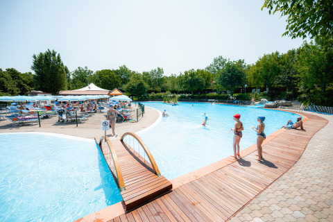 Piscina all’aperto con lettini, ombrelloni e ospiti al Centro Vacanze San Marino, parco vacanze a San Marino.