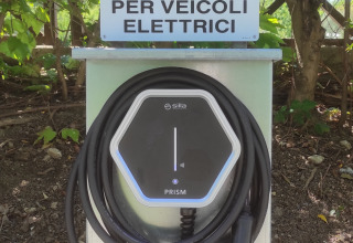 Laadpaal voor elektrische auto's bij Centro Vacanze San Marino, omringd door natuur en groen.