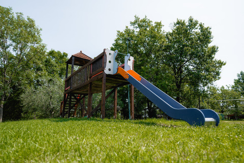 Aire de jeux avec toboggan et structure en bois au Centro Vacanze San Marino, entourée d’arbres verts.