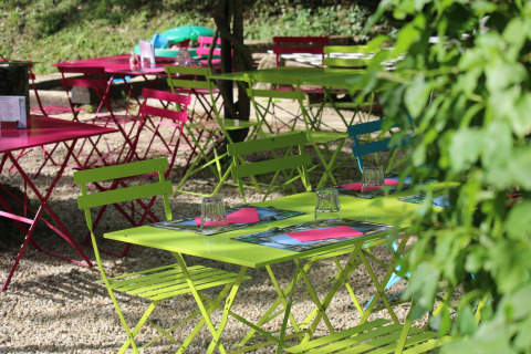 Colorful outdoor tables and chairs at Campsite Moulin de Chaules, a holiday park in Auvergne-Rhône-Alpes, France.