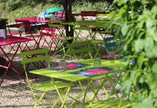 Colorful outdoor tables and chairs at Campsite Moulin de Chaules, a holiday park in Auvergne-Rhône-Alpes, France.