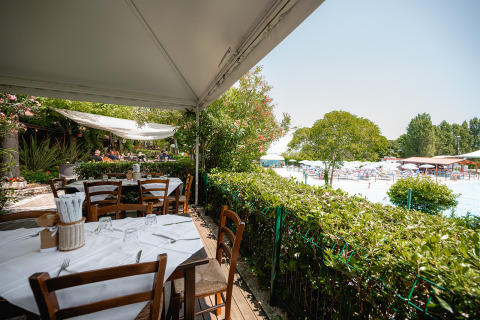 Espace de restauration extérieur surplombant la piscine et les transats au Centro Vacanze San Marino.