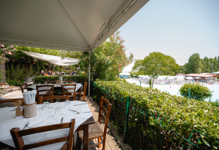 Udendørs restaurantområde med udsigt over swimmingpool og liggestole på Centro Vacanze San Marino.